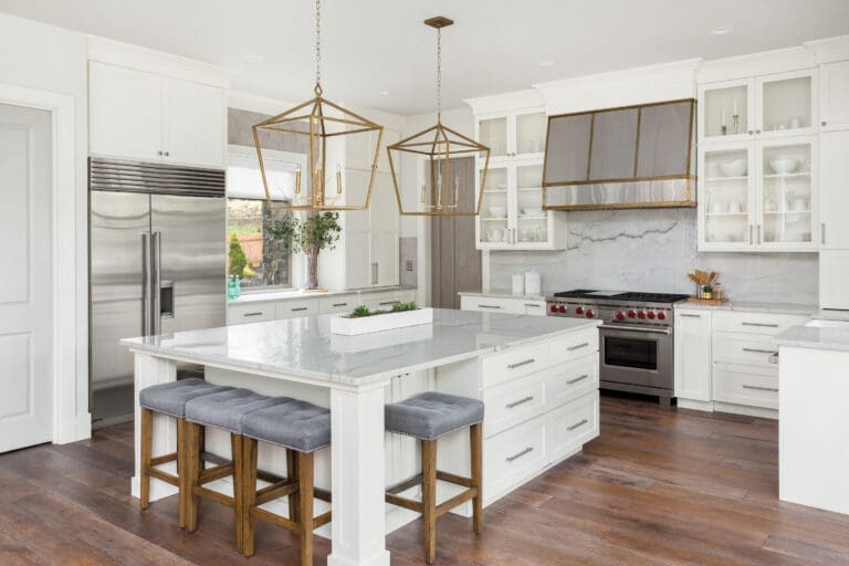 Beautiful Kitchen In New Luxury Home With Island, Pendant Lights, And Hardwood Floors