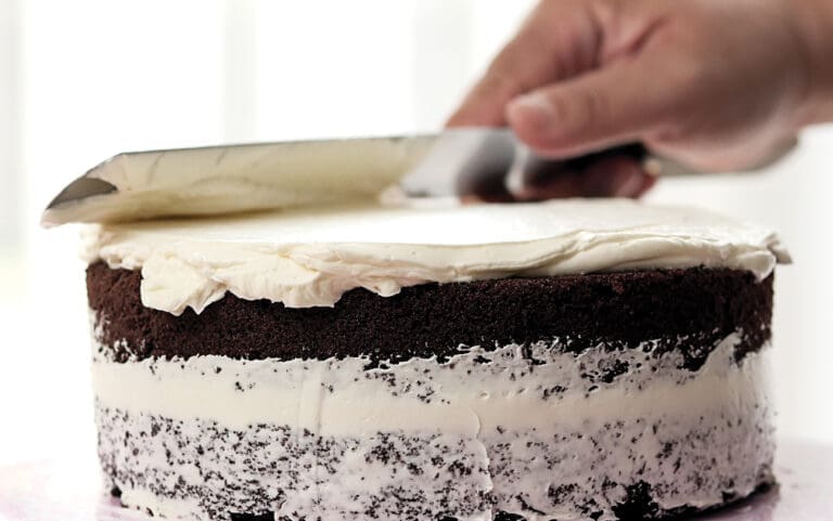 Spreading White Butter Cream On Homemade Chocolate Cake.