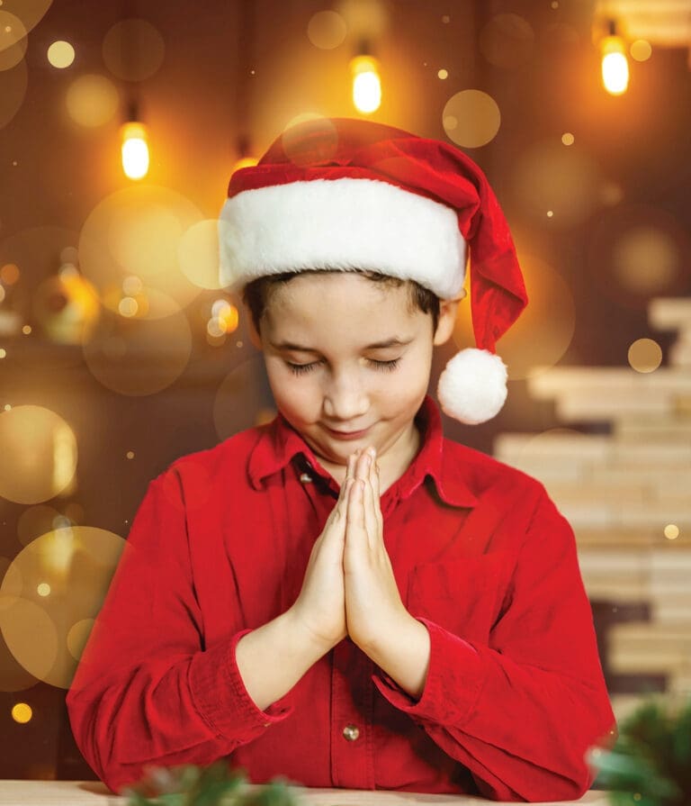 Praying child in Christmas hat