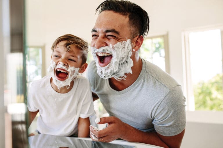 Father And Son Having Fun While Shaving In Bathroom