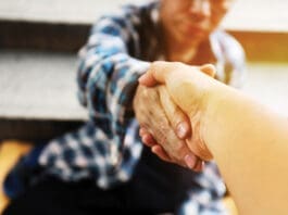 Close Up Handshake For Help Homeless Man On Walking Street In The Capital City.